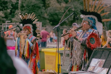 Zwei Indianer, die Holzblasinstrumente spielen