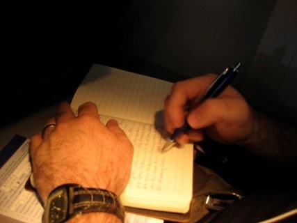 Someone writing in a sleep diary