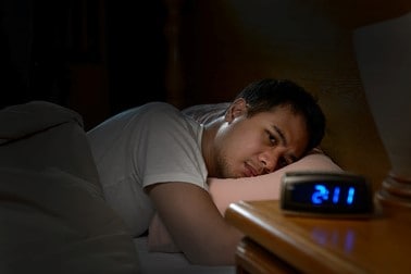 Man lying awake in bed