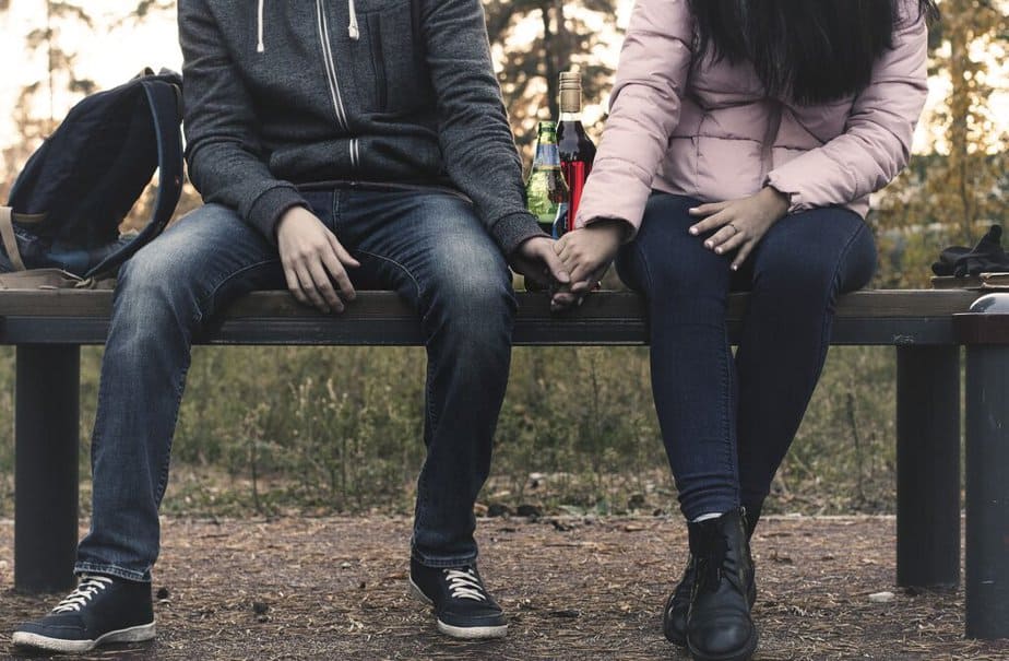 Two people sitting with alcoholic drinks between them