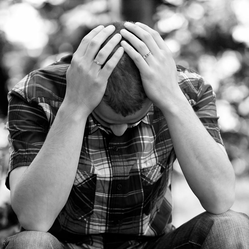 person sitting with hands on head